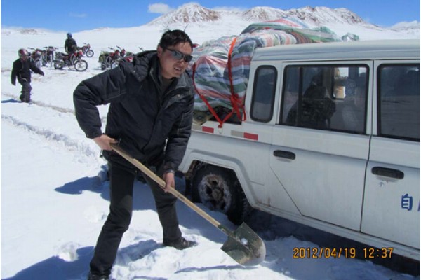 援藏干部周正宝同志正在铲除车轮下的积雪